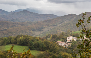 Vue (du Camp de Canebière - 849m) en contrebas sur le village de Péreille d'en haut  et le Massif de Tabe dans les nuages.