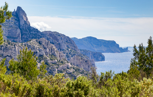 Après le col des Escourtines, sur le sentier des crêtes de Morgiou vue sur la côte des Calanques jusqu'au Bec de l'Aigle avant La Ciotat. L'aiguille de Sugiton à gauche.